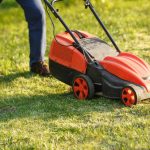 person mowing lawn in summer